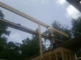Carpenter setting a ridge beam over a new addition frame — Ice Dam Removal by Roofing Brothers in Cabot