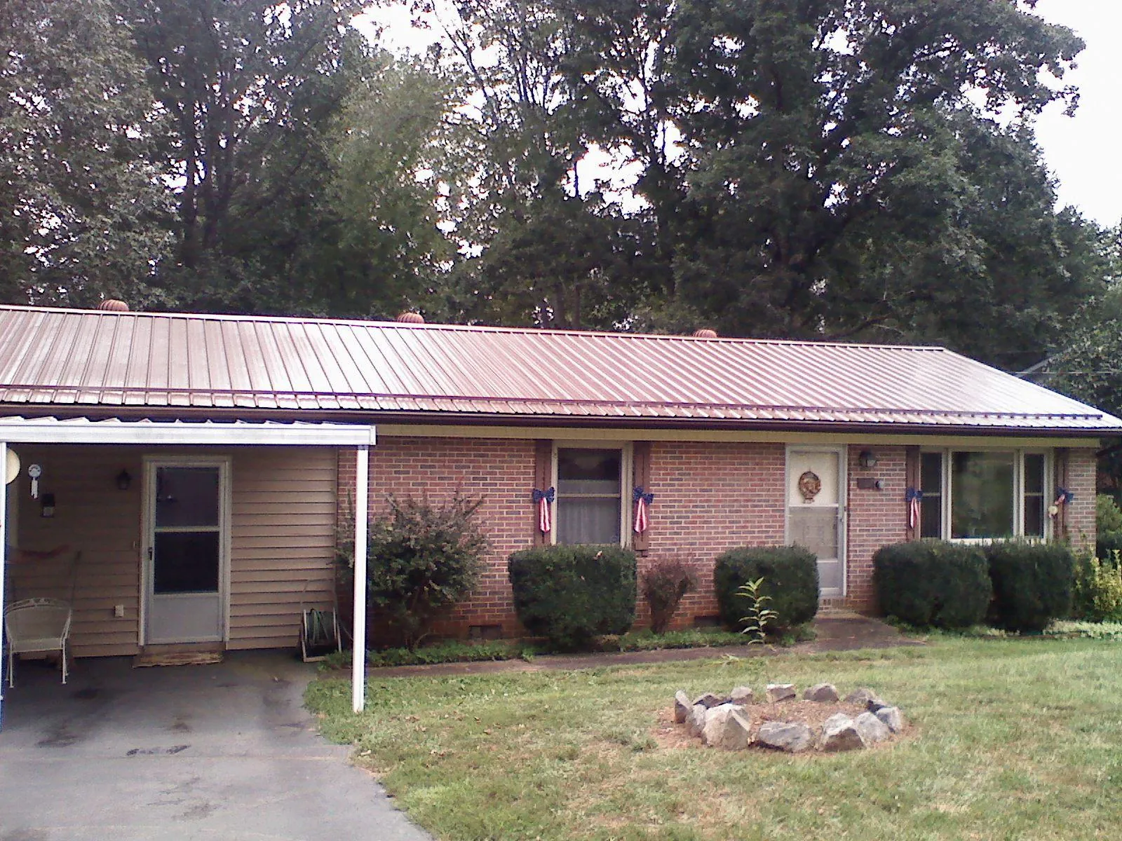 Bronze metal roof and carport on a brick ranch home — Roof Repair work by our crew in Cabot